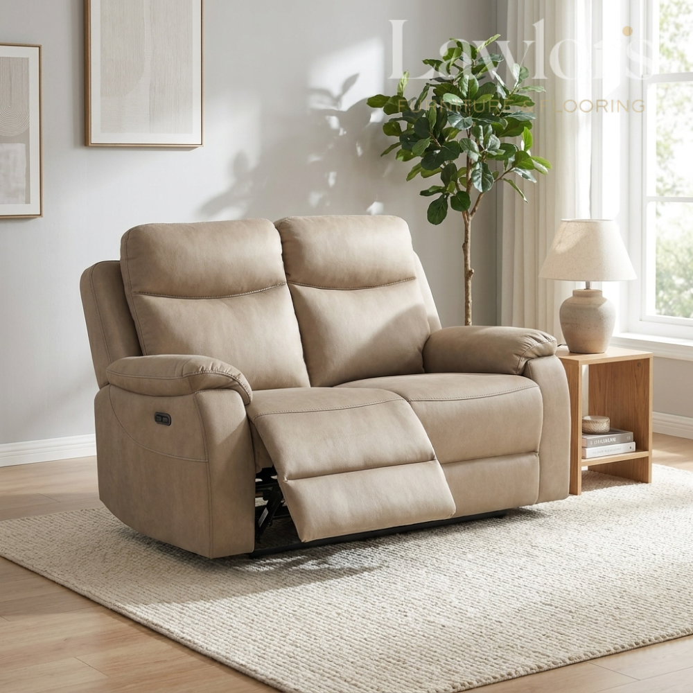 Beige recliner 2 seater sofa in a living room setting with a plant and lamp.