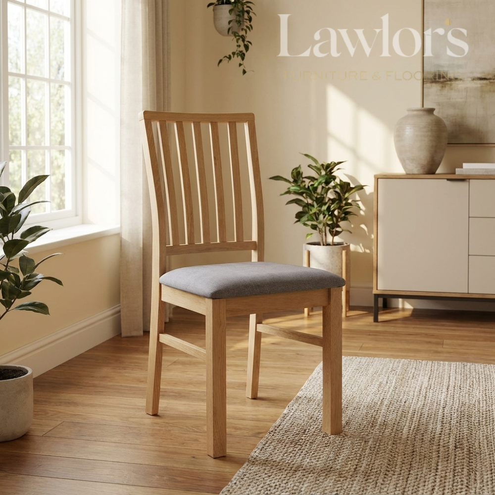 Wooden chair with gray cushion in a bright room with plants and a cabinet.