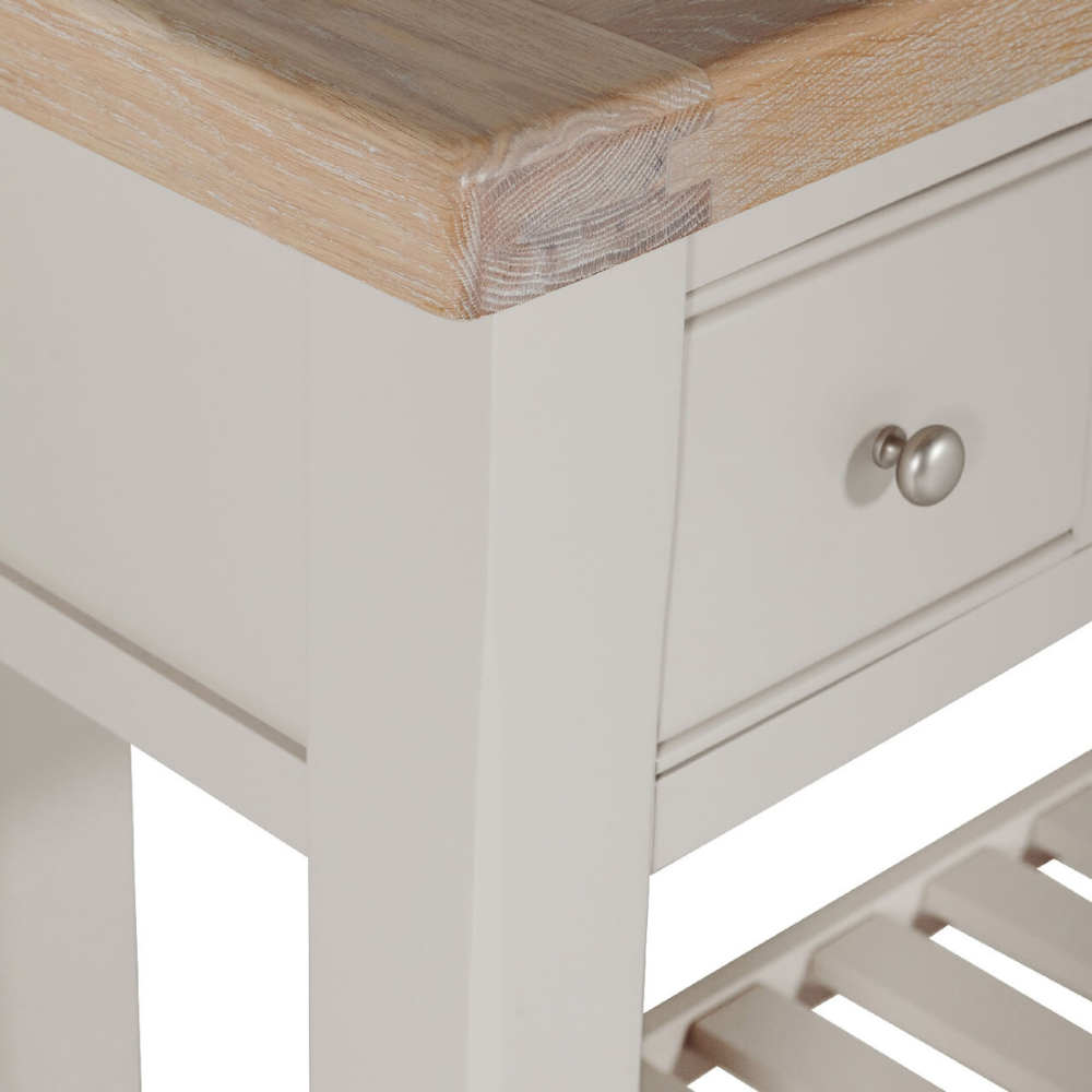 The Doune Console Table in Taupe features a sleek taupe finish, design with three drawers and a lower slatted shelf.