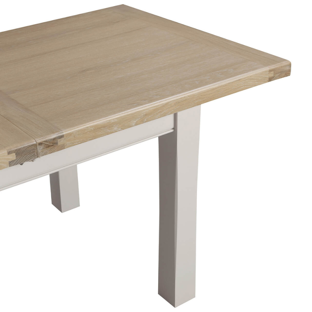 The Doune Extendable Dining Table in Taupe, 1800-2460mm features oak top, taupe-painted legs, and smooth extension mechanism.