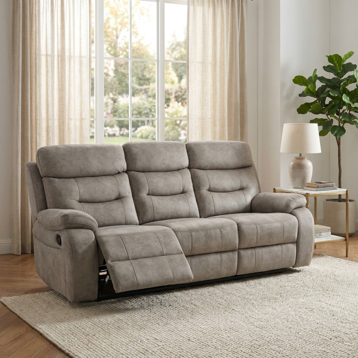 Cream 3 seater reclining sofa in a living room with large windows and a plant.