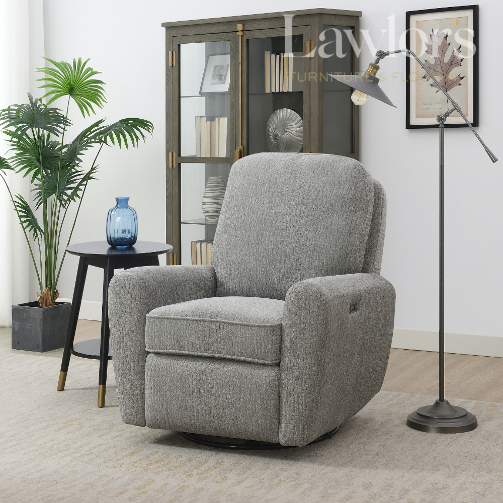 Grey electric recliner chair in a living room setting with a plant, side table, and lamp.