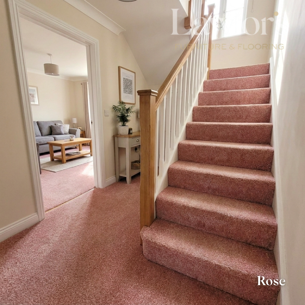 Staircase with rose-colored carpet leading to a living room