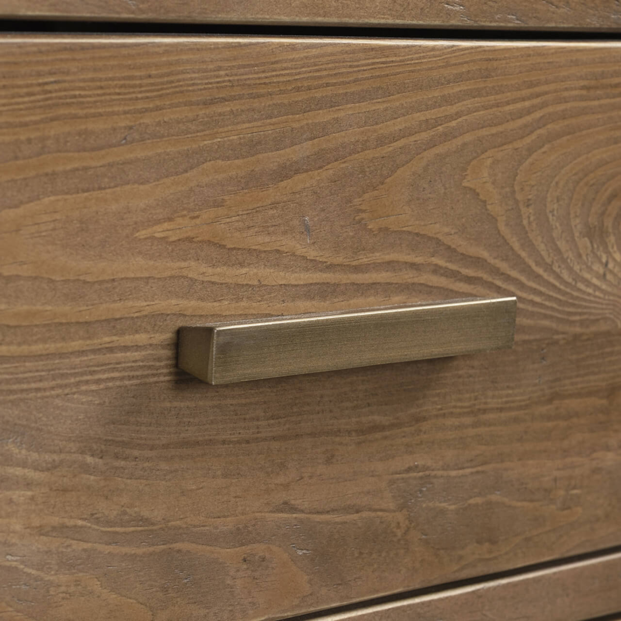 Brass cabinet handle on a wooden drawer