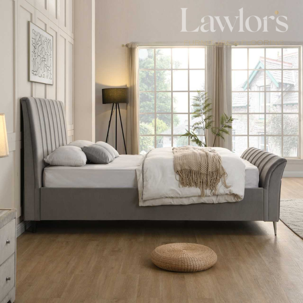 Modern bedroom with a grey upholstered bed, white bedding, and decorative pillows.