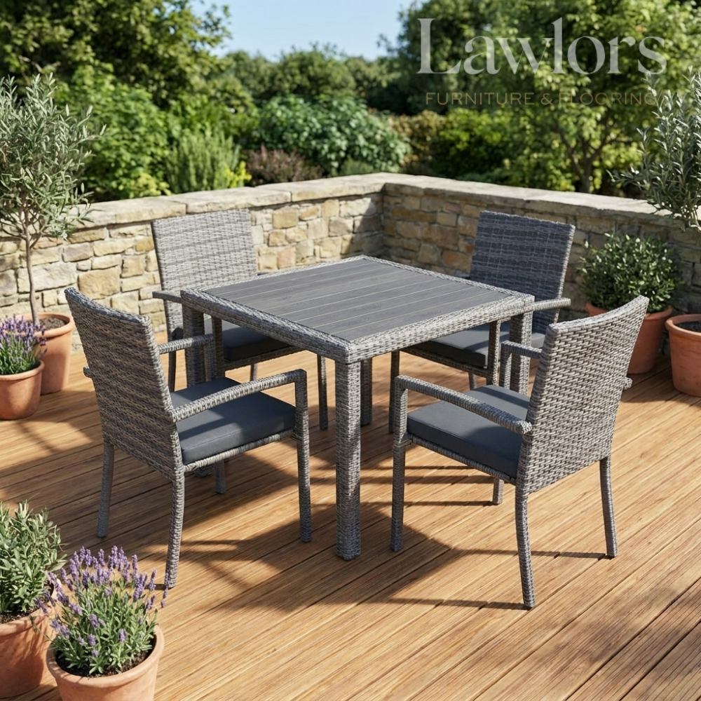 Outdoor garden furniture patio set with a table and chairs on a wooden deck, surrounded by plants.