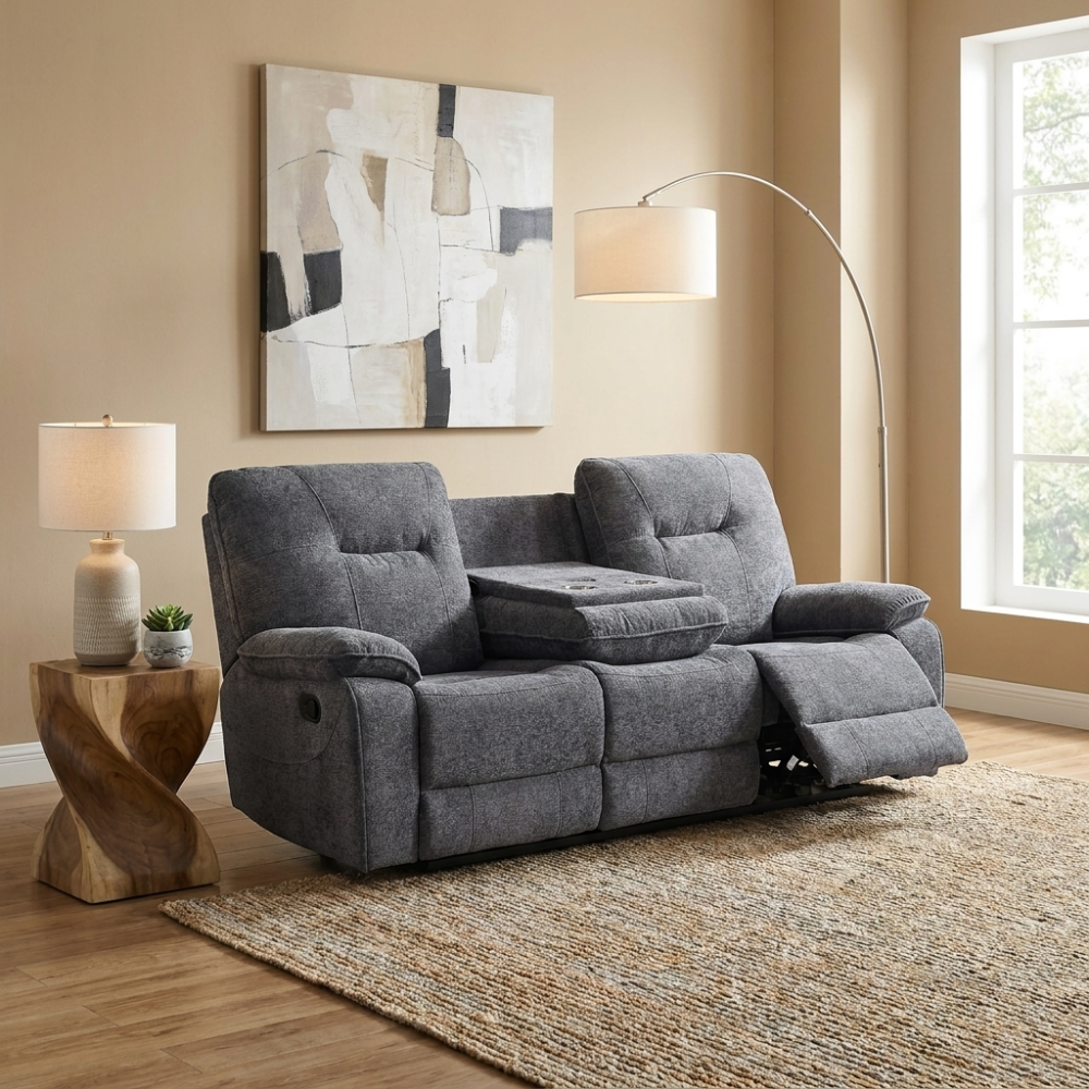 Dark grey 3 seater recliner sofa in a living room with a rug, lamp, and abstract painting.