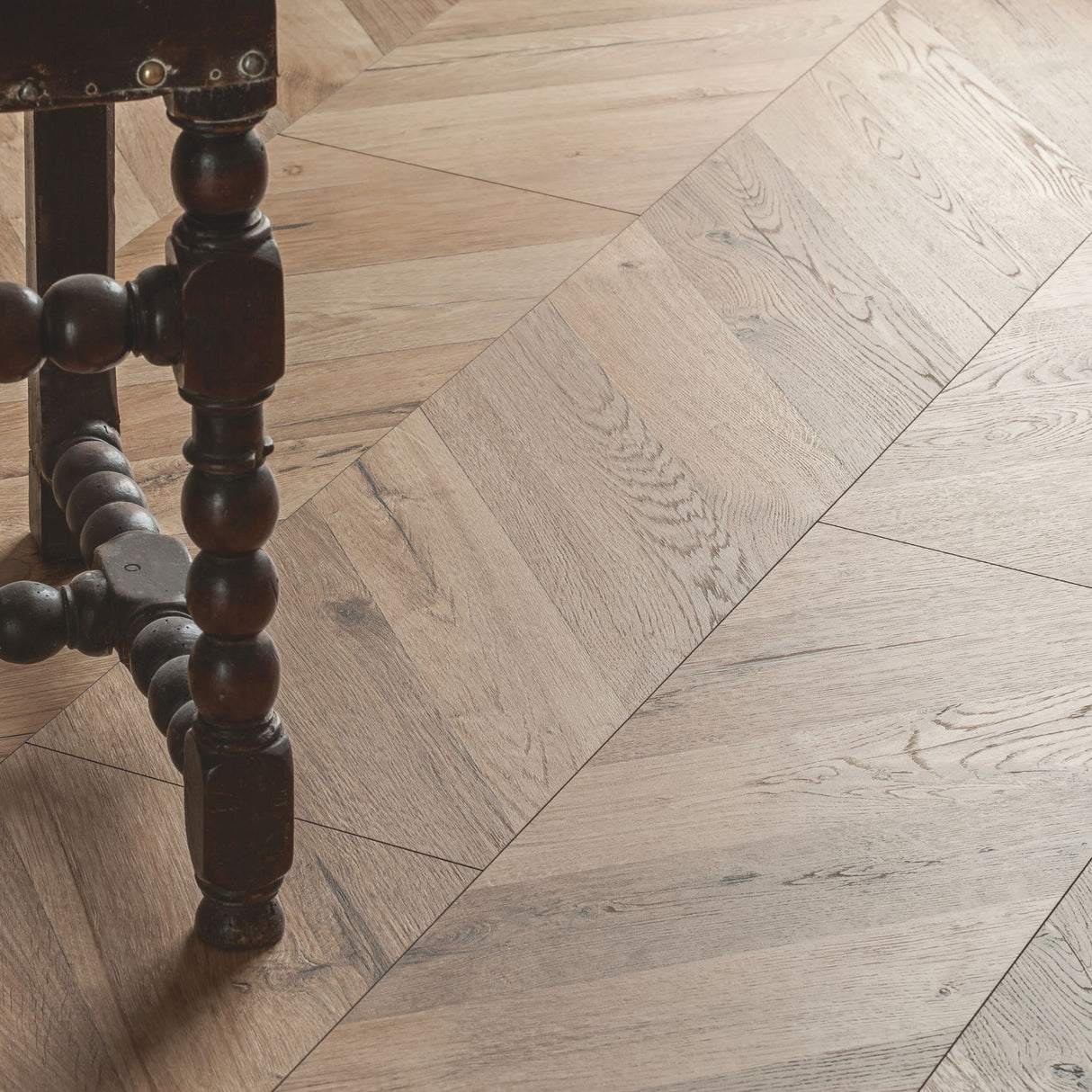Rochesta Oak Laminate Flooring 8mm in chevron style featuring AC4 durability, easy installation, and a warm rustic oak finish.