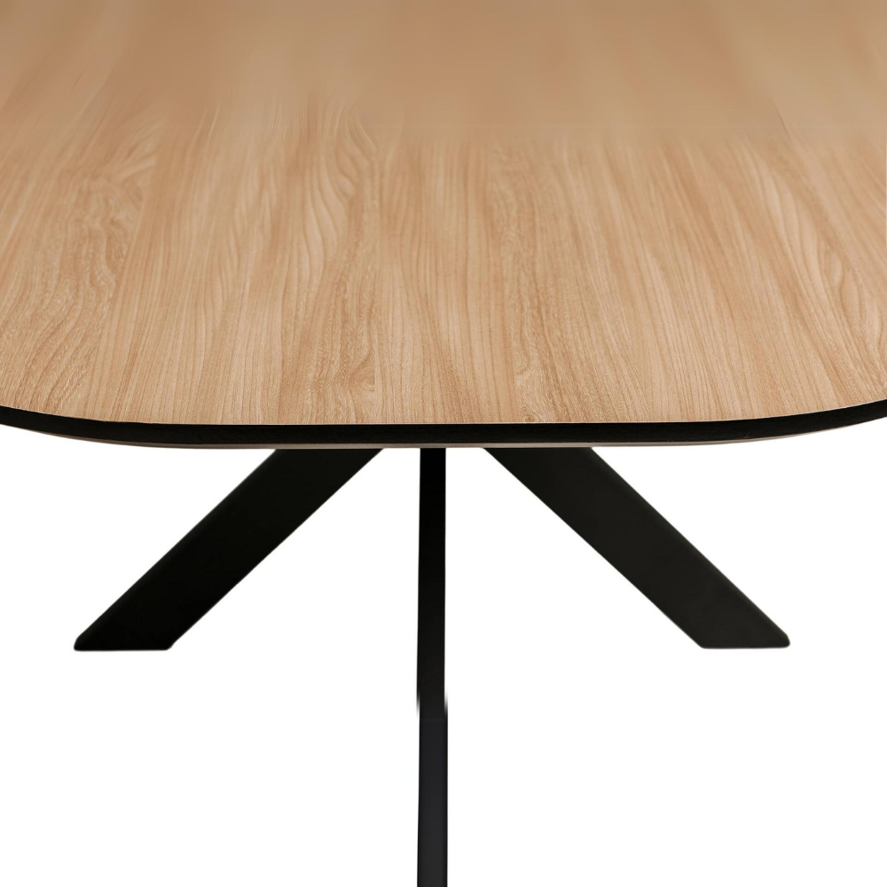 The Sadia Oval Dining Table in Oak features a durable, heat, stain, and scratch-resistant melamine top with a black metal base.