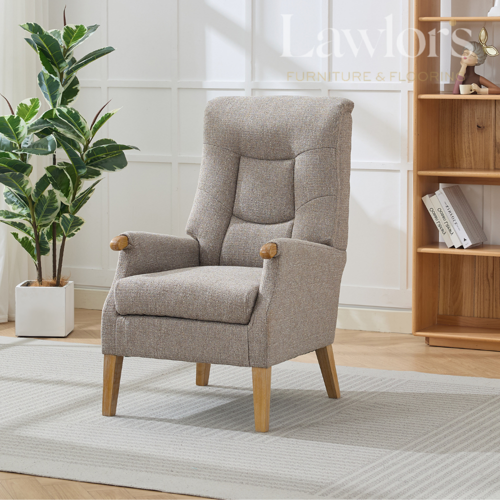 Beige armchair in a room with a plant and wooden bookshelf.