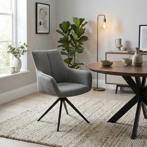 Grey fabric swivel chair in sitting room setting with dining table