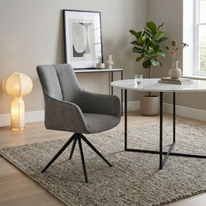 Grey fabric swivel chair in sitting room setting with dining table