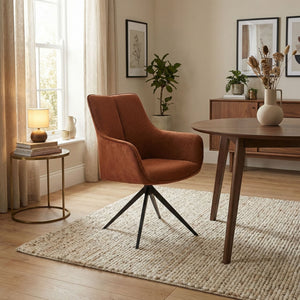 Orange fabric swivel chair in sitting room setting in dining table