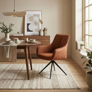 Orange fabric swivel chair in sitting room setting with dining table
