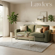 An olive green fabric sofa in a beautifully styled living room, decorated with neutral and earthy throw pillows, a wooden coffee table, a textured rug, and potted plants.