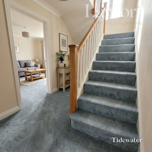 Staircase with gray carpet leading to a living room