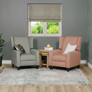 Two armchairs in a living room with a window and rug.