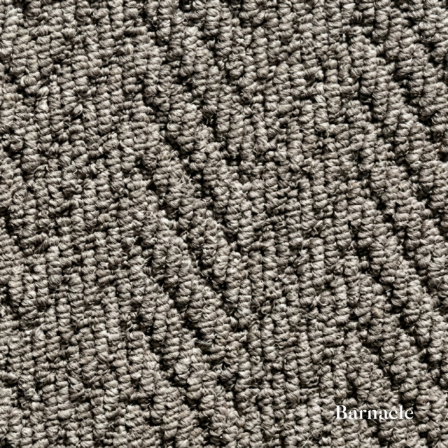 Close-up of textured gray carpet with 'Barnacle' branding.