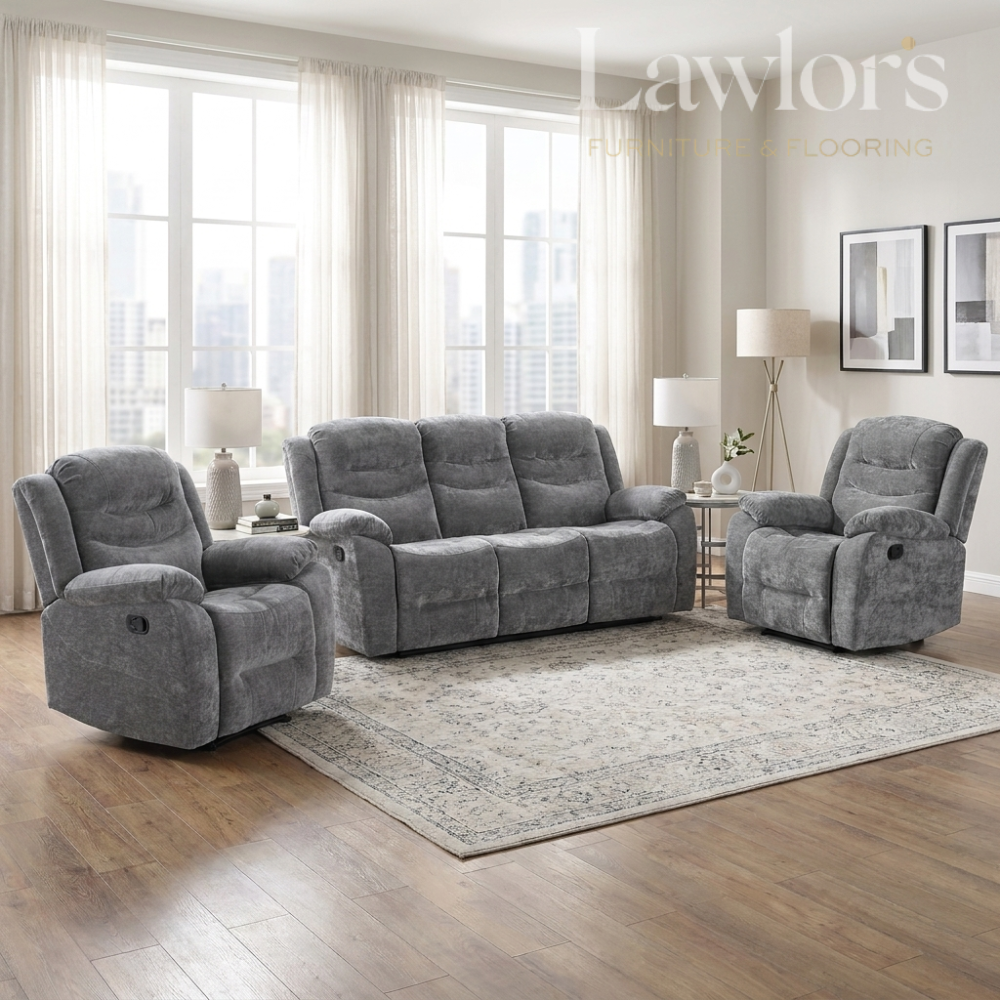 A 3+1+1 grey reclining living room furniture set consisting of a 3 seater and two 1 seater sofas arranged on a patterned area rug in a bright, modern living room.