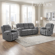 A 3+1+1 grey reclining living room furniture set consisting of a 3 seater and two 1 seater sofas arranged on a patterned area rug in a bright, modern living room.