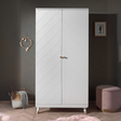 The Billy 2 Door Wardrobe in Satin White with golden accents and 2 door cabinet offers ample clothing storage door any stylish baby or children's room