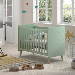The Billy Baby Cot Bed in Olive Green features a geometric graphic design, golden accents and an adjustable slatted base, perfect for a modern nursery setup