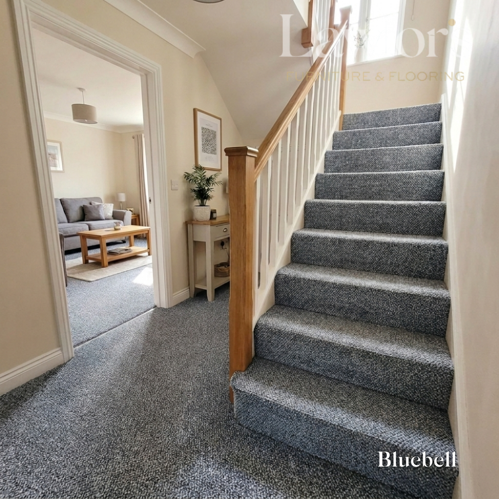 Staircase with blue carpeting leading to a living room