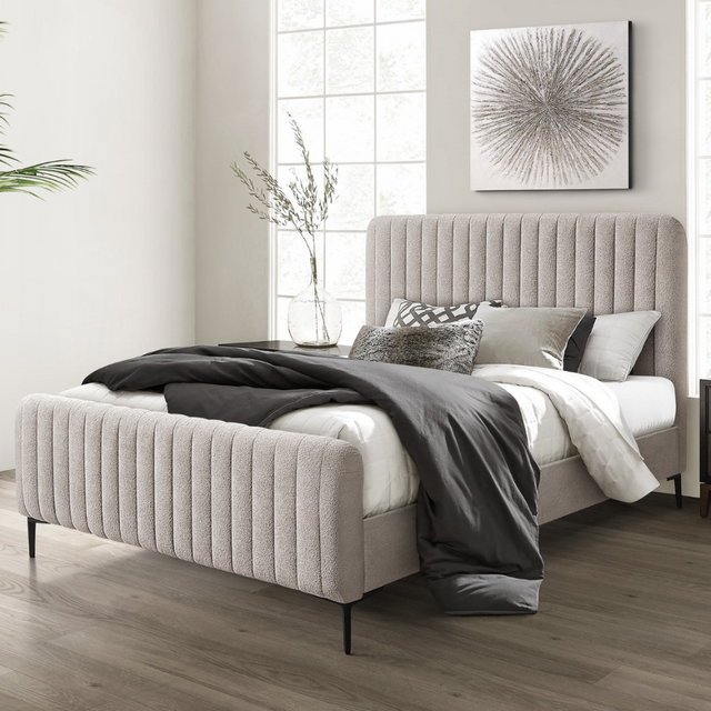 The Clarissa Bed in Grey or Beige features chic channelled upholstery, sturdy metal legs, and padded headboard.