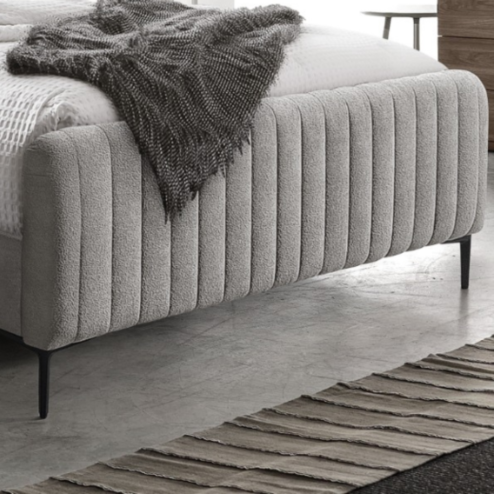 The Clarissa Bed in Grey or Beige features chic channelled upholstery, sturdy metal legs, and padded headboard.