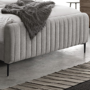 The Clarissa Bed in Grey or Beige features chic channelled upholstery, sturdy metal legs, and padded headboard.