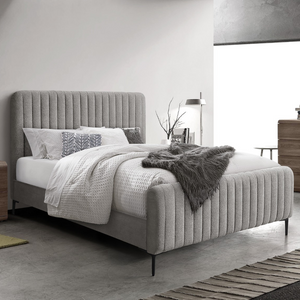 The Clarissa Bed in Grey or Beige features chic channelled upholstery, sturdy metal legs, and padded headboard.