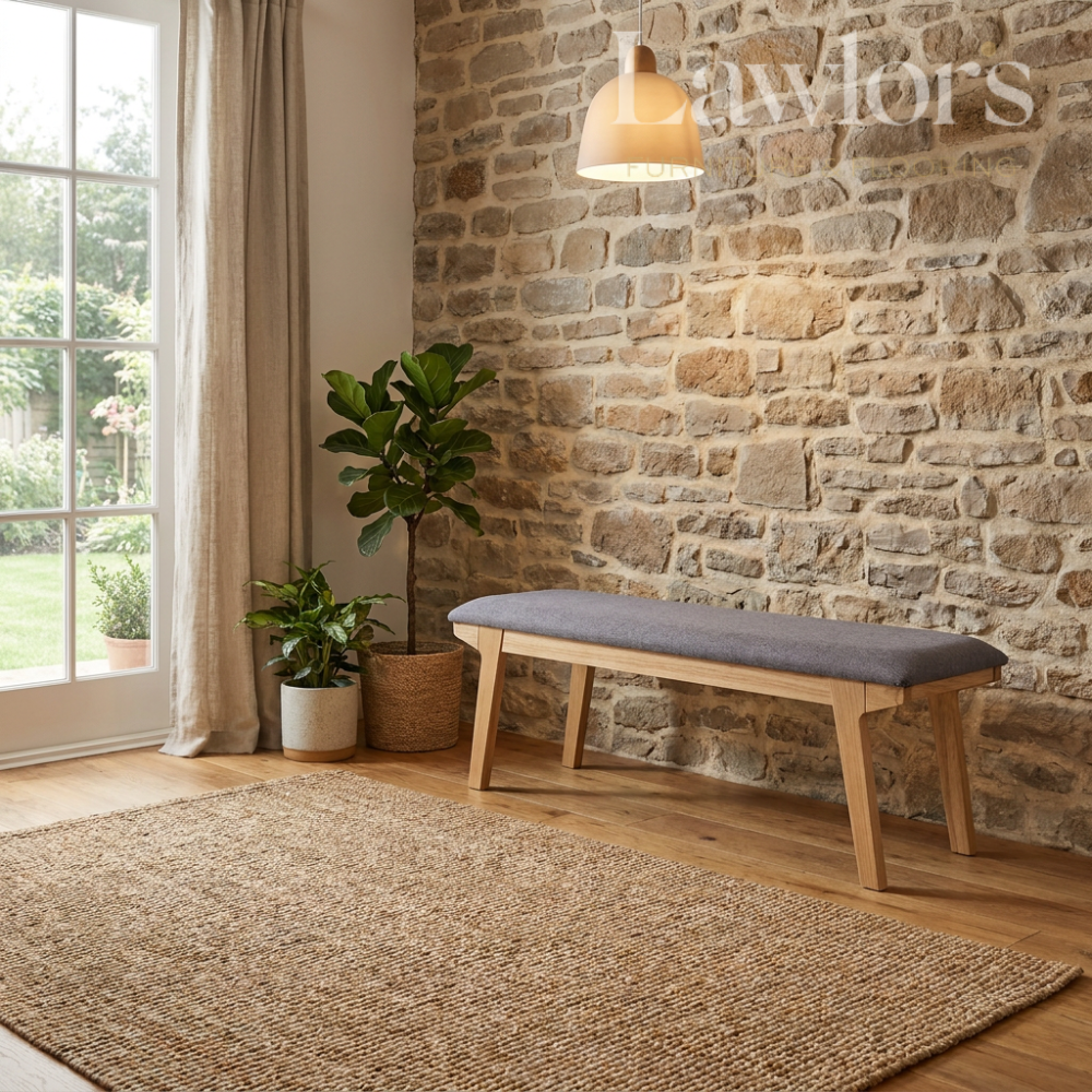 Nestled corner of a room with a stone wall, wooden dining bench, and plants.