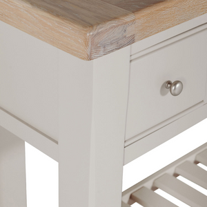 The Doune Console Table in Taupe features a sleek taupe finish, design with three drawers and a lower slatted shelf.