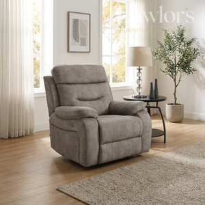Cream recliner chair in a living room setting with a lamp and plant.