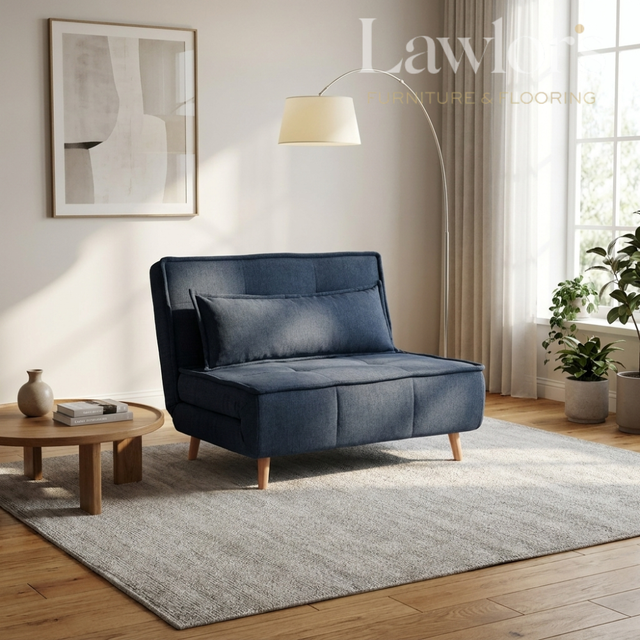 Modern living room with a blue sofa bed, round table, and decorative elements
