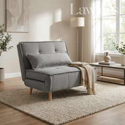 Grey sofa bed in a living room setting with a lamp and decor items.