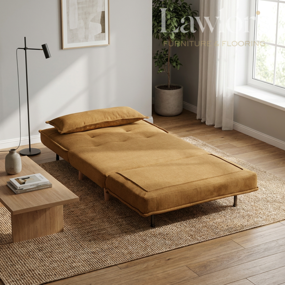 Brown sofa bed in a room with a rug, coffee table, and lamp.