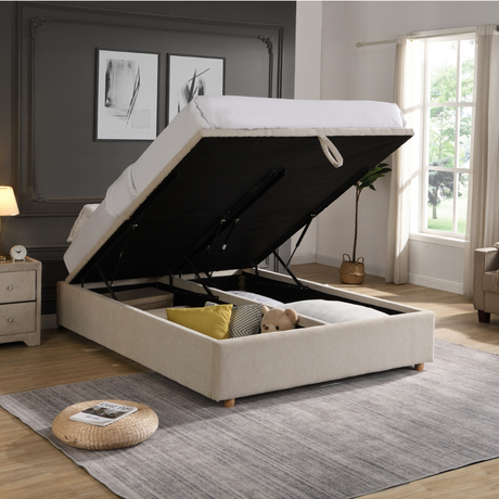 The Emma Gas-Lift Fabric Ottoman features soft-touch beige fabric, soft button details, convenient storage and subtly winged sides.