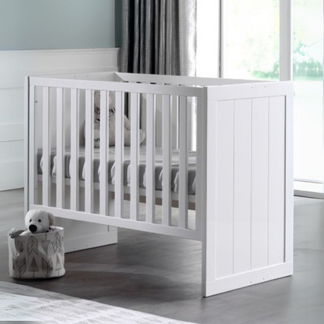 The Erik Baby Cot Bed 60 x 120cm in White features a adjustable slat base with 3 heights, stylish vertical grooves and durable MDF design