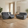 A gray upholstered reclining loveseat and matching armchair shown in a bright living room with wood floors, a woven rug, curtains, and plants.