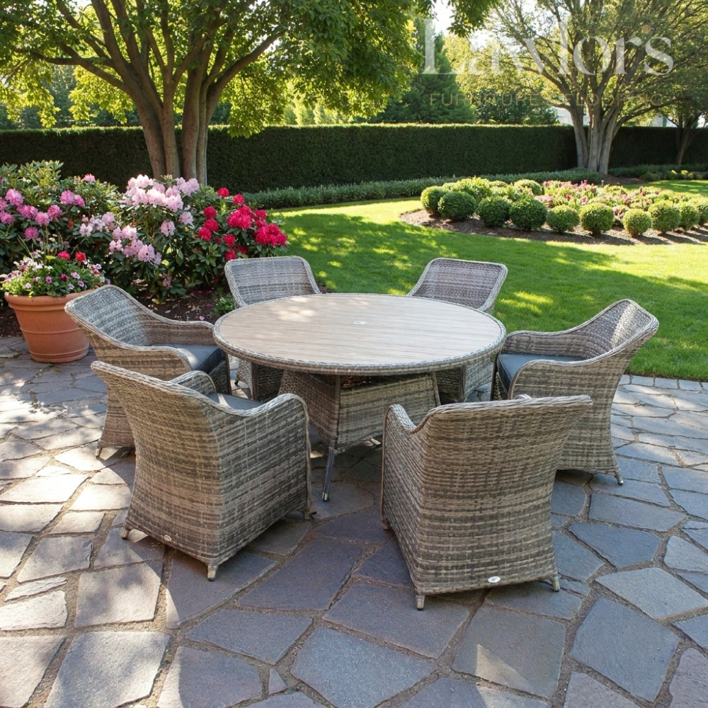 Garden furniture patio set with round table and chairs on a stone patio with garden in the background