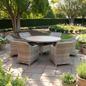 Outdoor garden furniture patio set with wicker chairs and a round table in a garden setting.