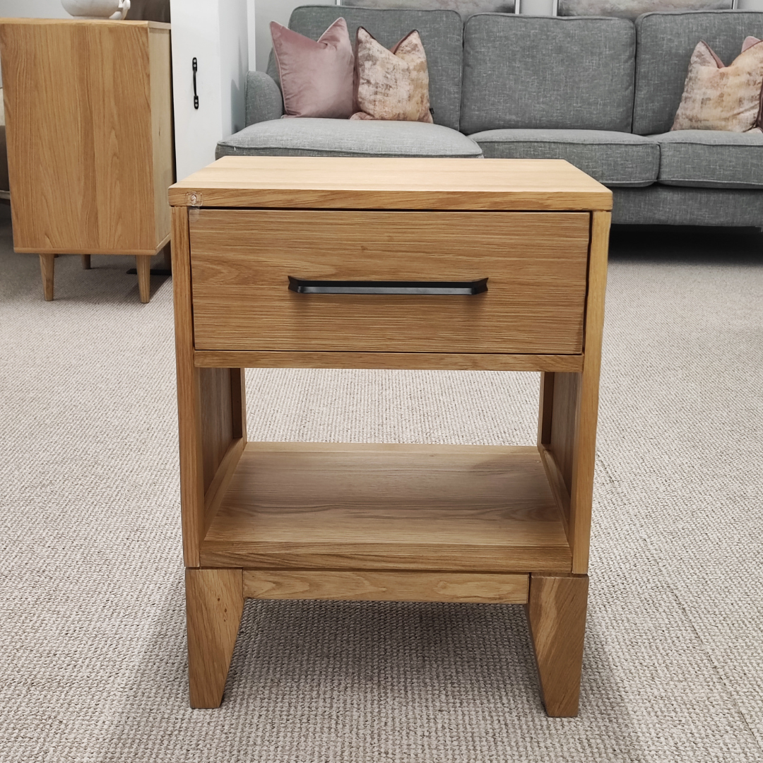 The Viento Bedside Locker Nightstand features a timeless oak build, sleek design with black handles, and ample storage.