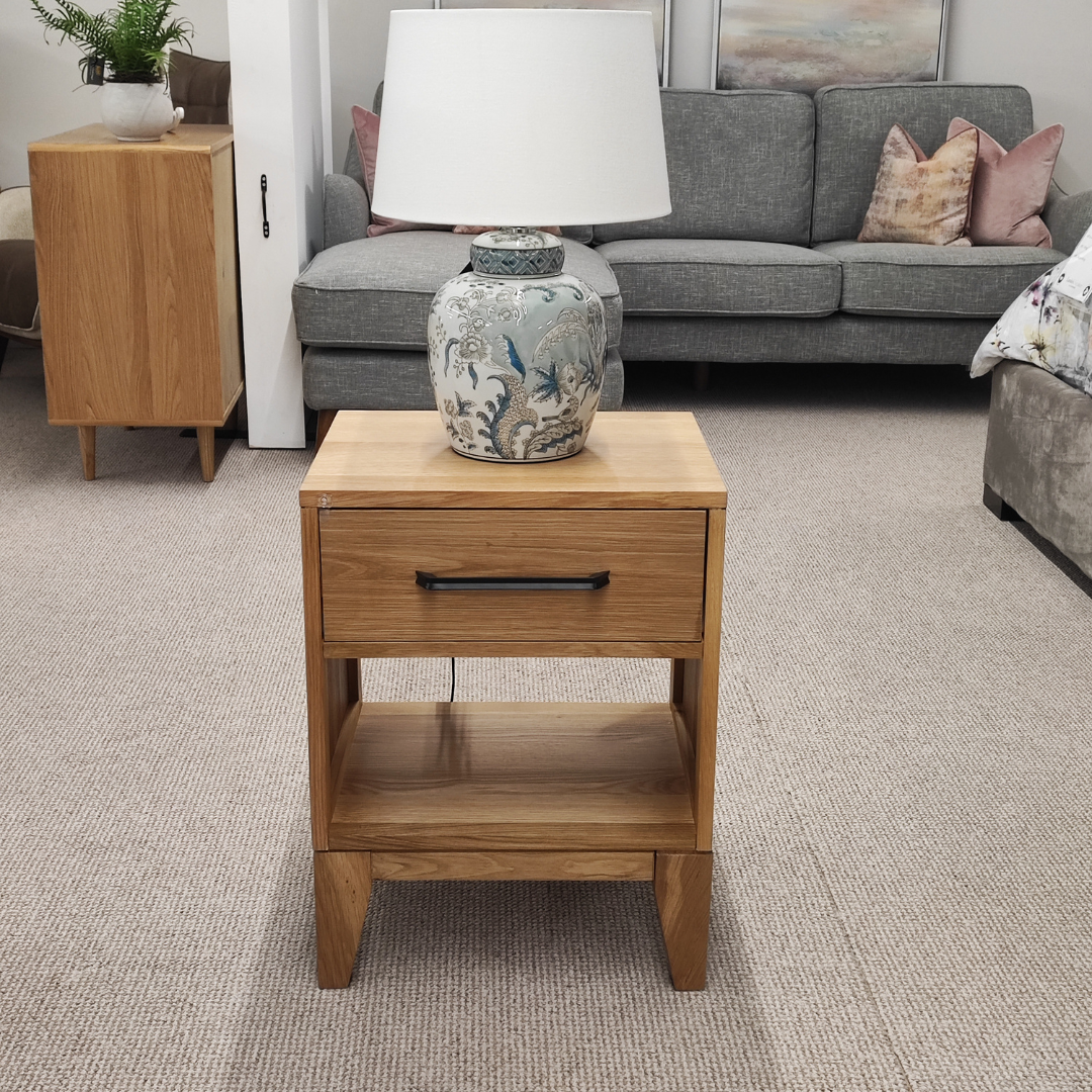 The Viento Bedside Locker Nightstand features a timeless oak build, sleek design with black handles, and ample storage.
