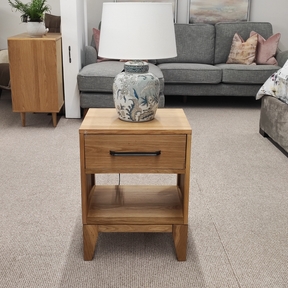 The Viento Bedside Locker Nightstand features a timeless oak build, sleek design with black handles, and ample storage.