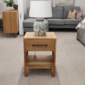 The Viento Bedside Locker Nightstand features a timeless oak build, sleek design with black handles, and ample storage.