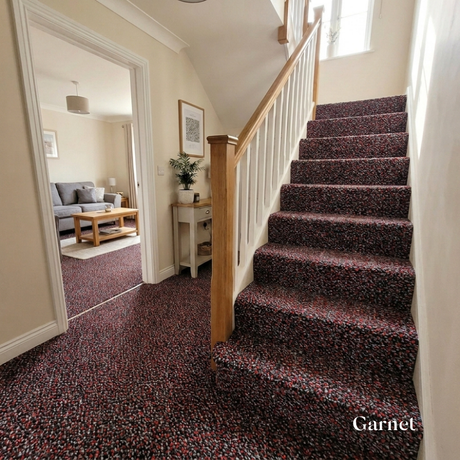 Staircase with garnet carpet leading to a living room.
