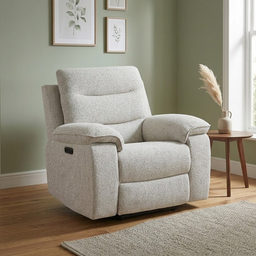A light beige textured fabric recliner chair shown in a styled living room setting with a wooden floor, sage green wall, framed botanical prints, a small wooden side table with a vase of pampas grass, and a neutral rug.