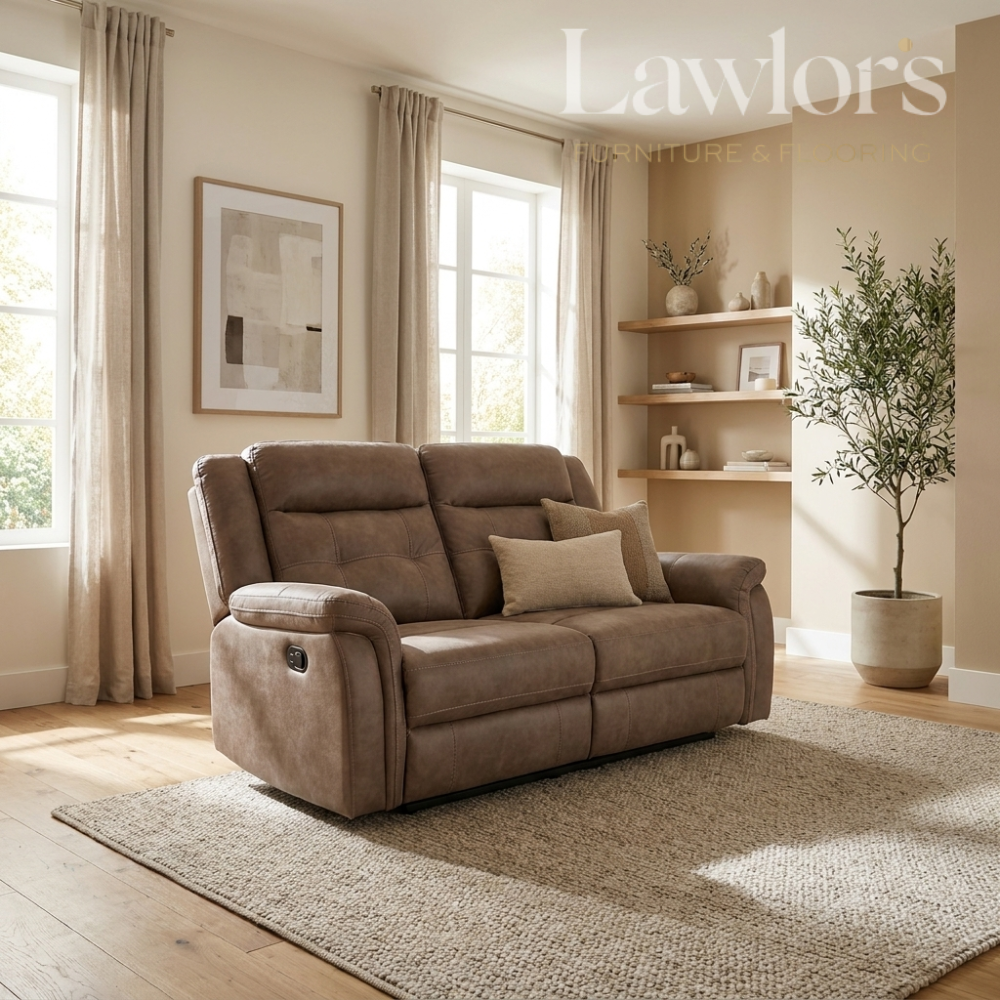 A brown upholstered reclining loveseat sofa placed in a styled living room with beige curtains, wood flooring, a rug, wall art, shelving, and a potted tree.