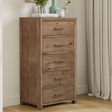 Wooden dresser with five drawers in a bedroom setting.